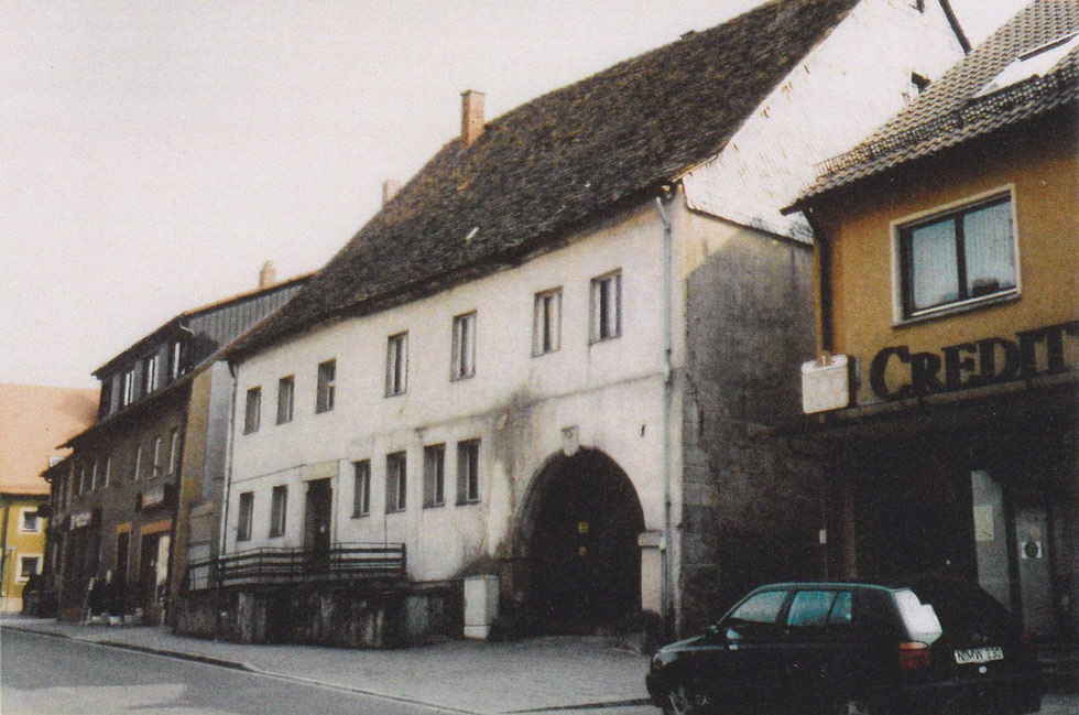 Ehemaliges Anwesen von Johann Georg Grienseyßen in Langenzenn: Weißes Gebäude mit einem großen Torbogen 